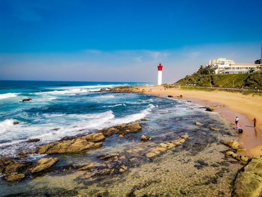 a beach with a light house in the background