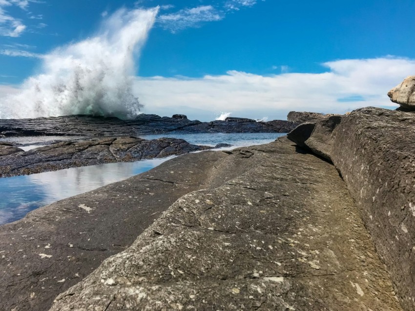 a large wave is crashing over the rocks