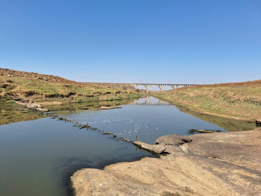 a river with a bridge in the background