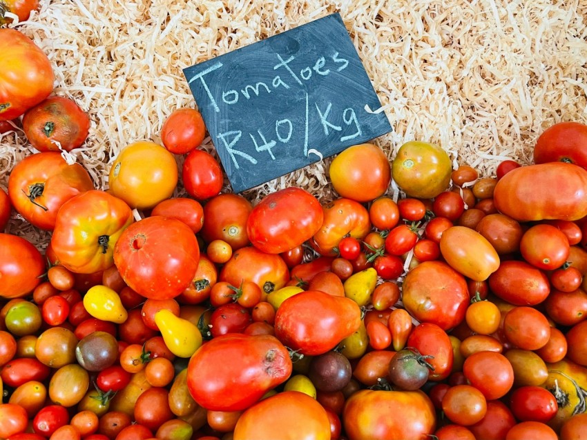 a pile of tomatoes and other fruits and vegetables KokS