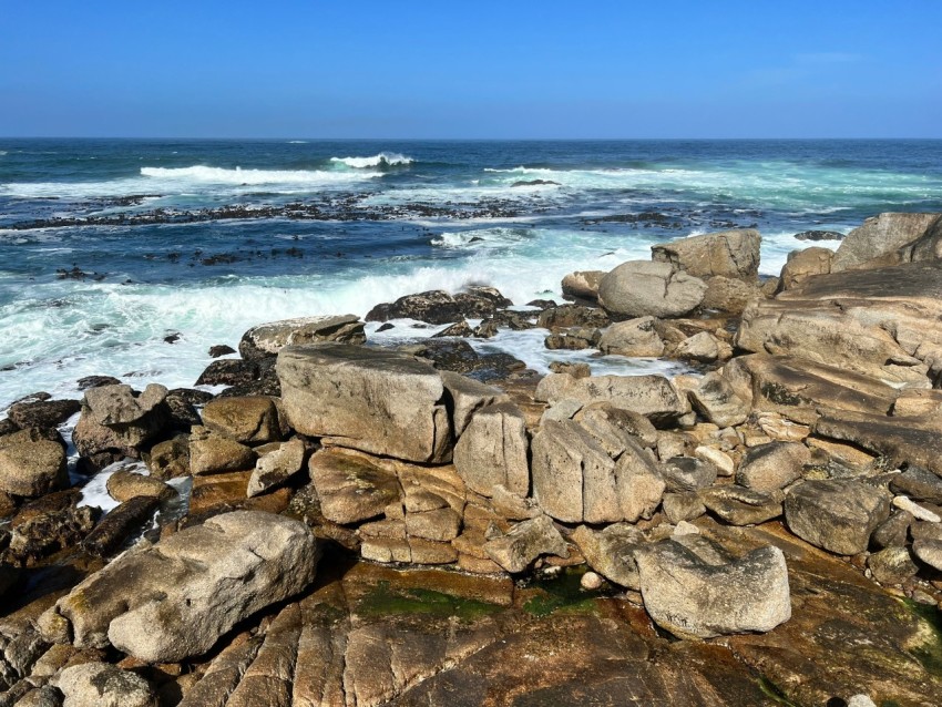 a rocky beach with waves coming in from the ocean