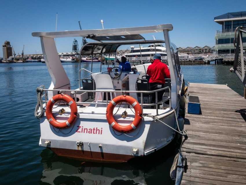 a boat docked at a pier with two people on it