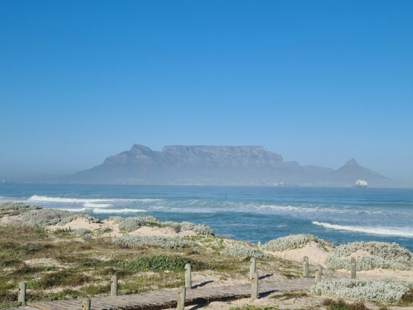 white sand beach with green trees and mountain in distance