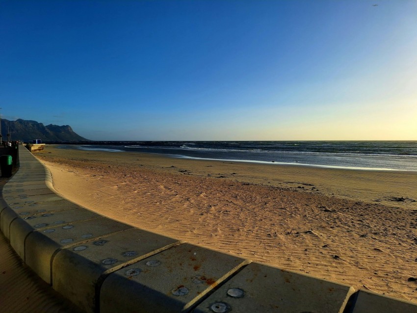 a view of a beach from the side of the road