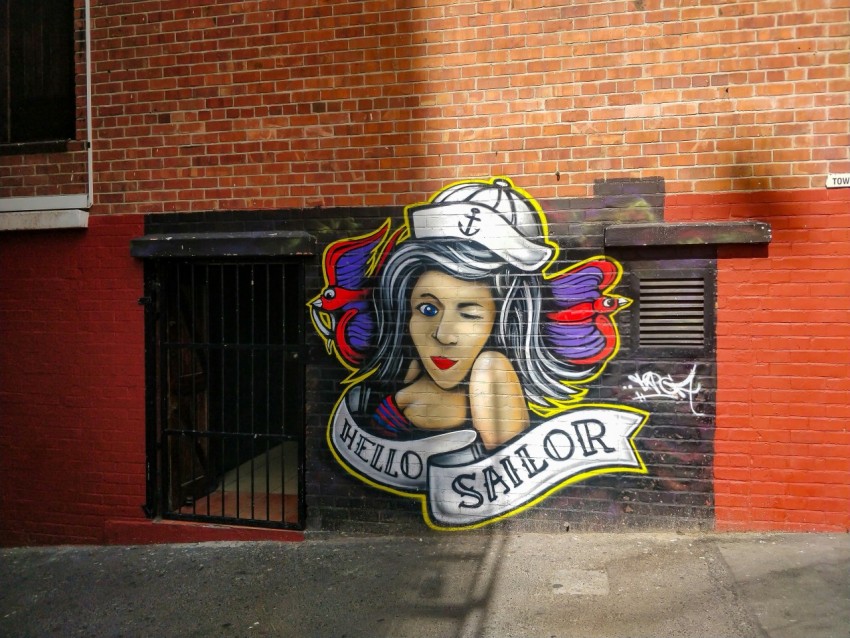 woman in black and white hat graffiti on brown brick wall