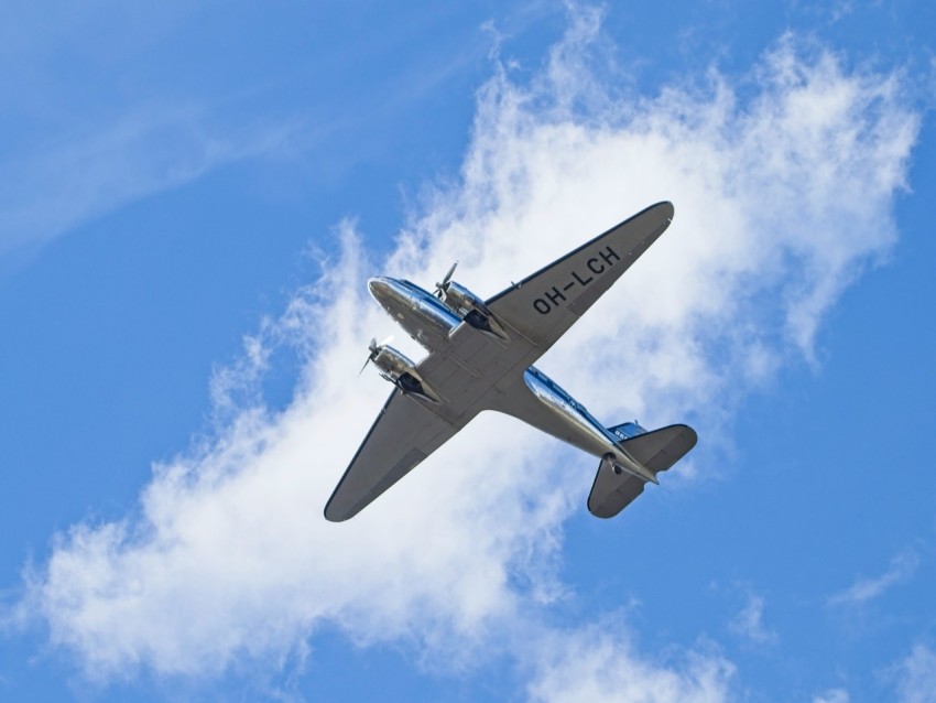 a small plane flying through a blue sky