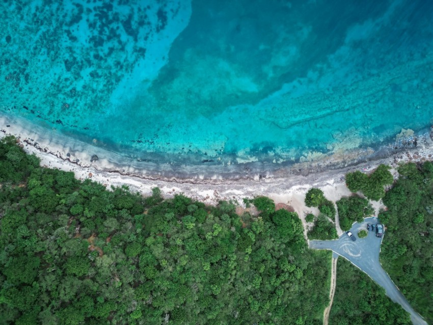 an aerial view of a sandy beach and blue water