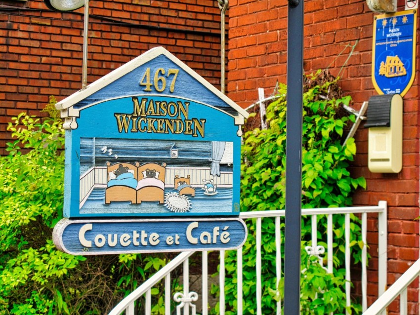 a sign for a cafe in front of a brick building