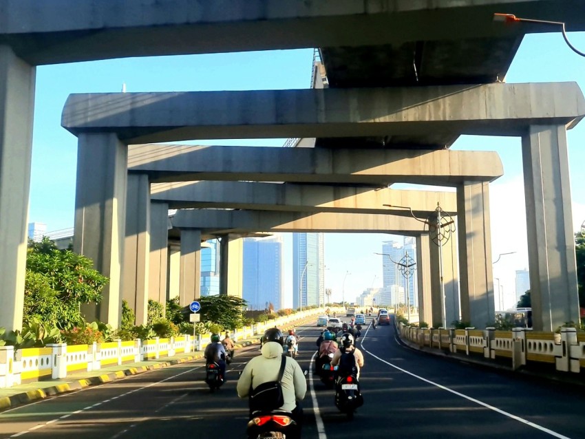 a group of people riding motorcycles down a highway