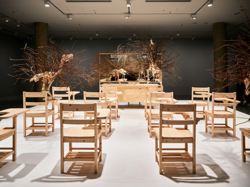 a room filled with lots of wooden chairs and tables