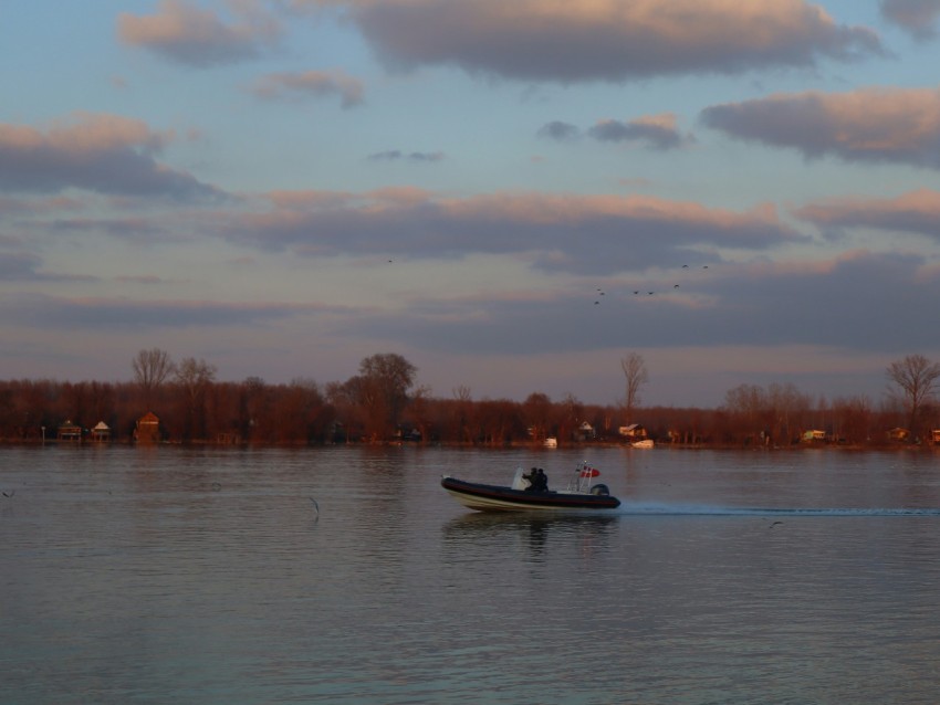 a man in a small boat on a large body of water