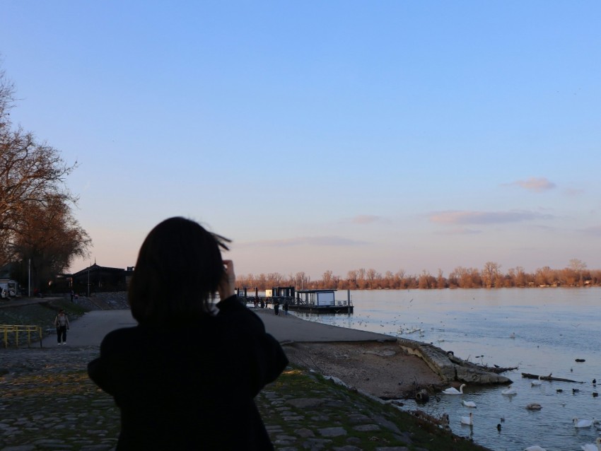 a woman standing next to a body of water