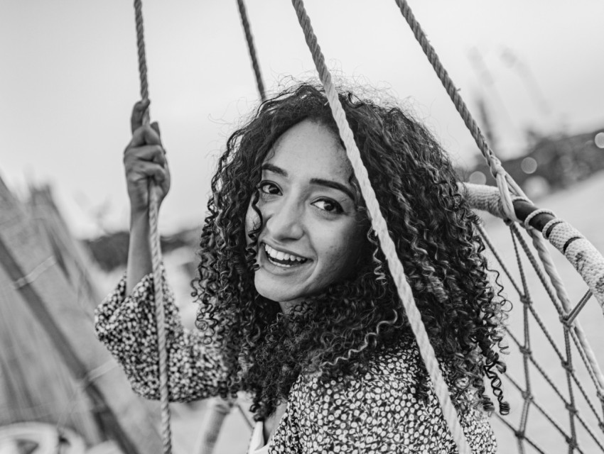 a woman smiling while sitting on a boat