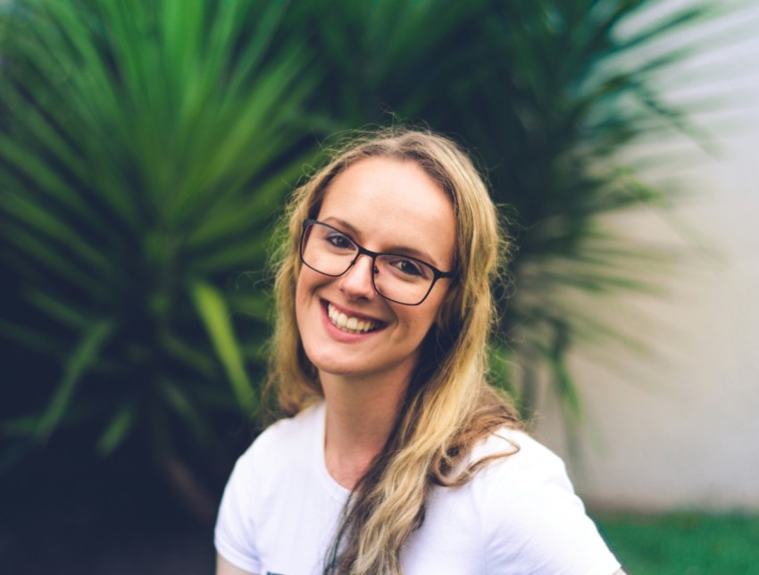 woman wearing white crew neck shirt near green leaf plant