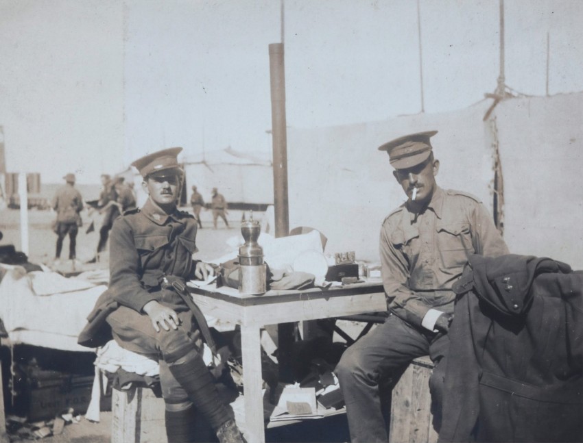 two men wearing police hats sitting in front of table _E5NV