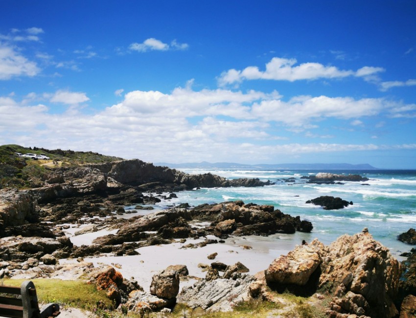 brown rocks on seashore under blue sky during daytime