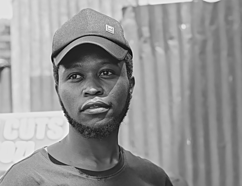 man in crew neck shirt wearing black and white fitted cap