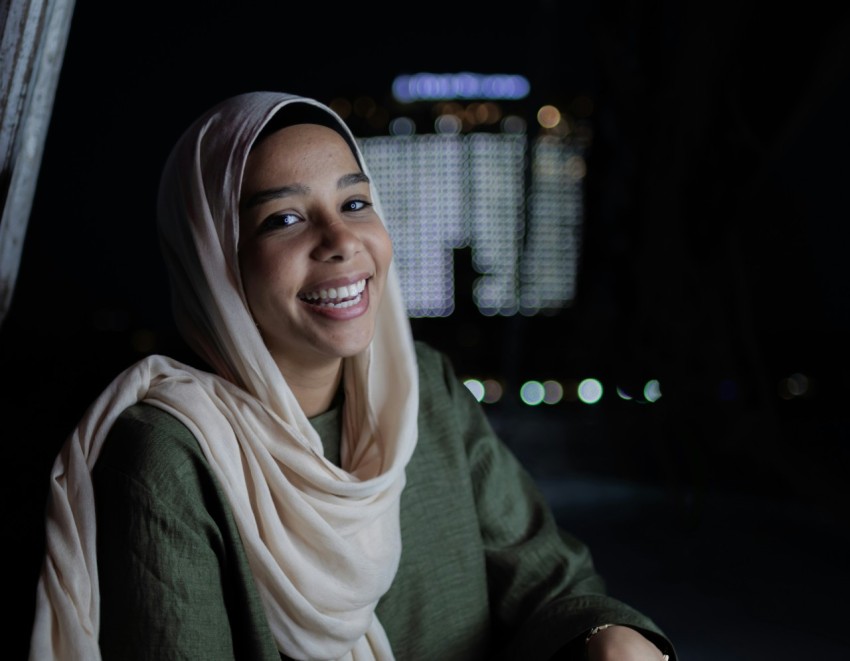 a woman in a headscarf smiles at the camera