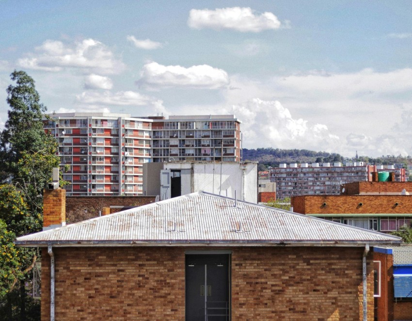 brown and white concrete buildings under white clouds during daytime