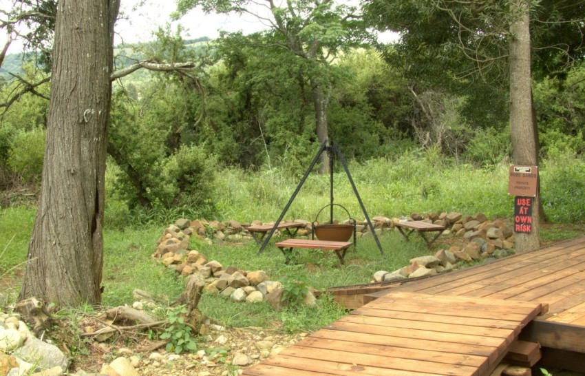 a wooden deck with a swing in the woods