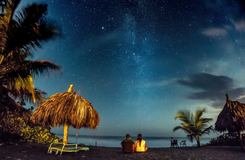 two person sitting near seashore