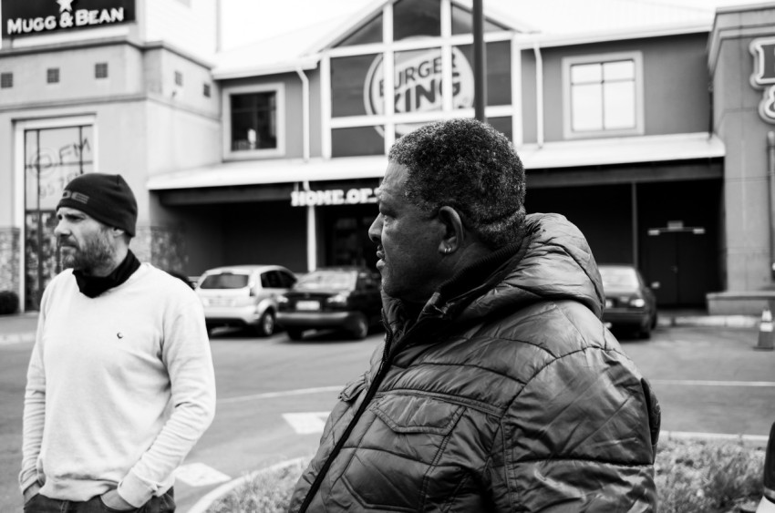 a black and white photo of two men standing in front of a building