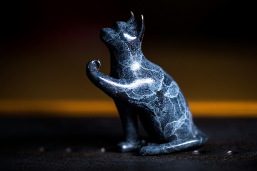 a black cat statue sitting on top of a table