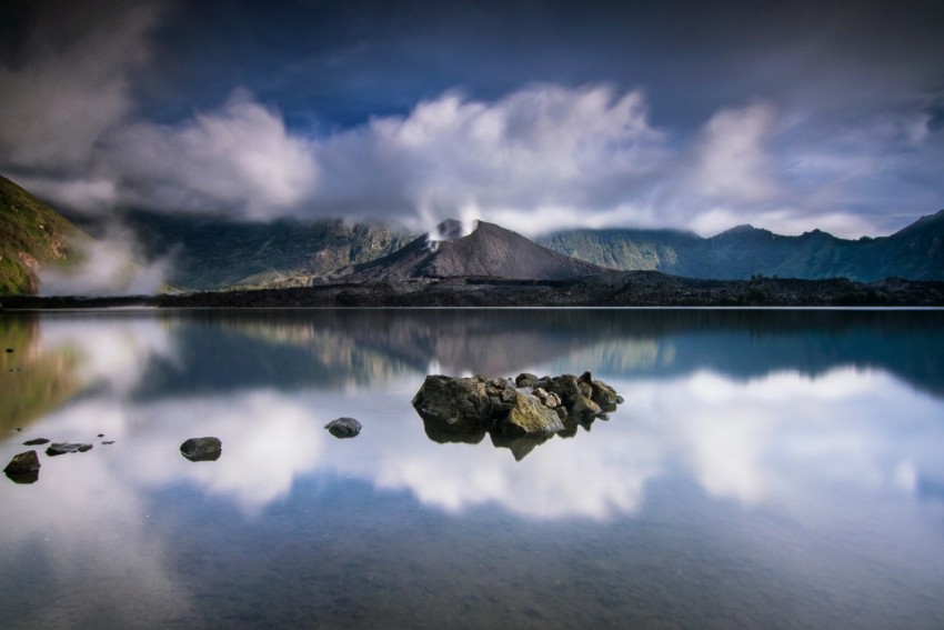 lake near mountain under blue sky during daytime