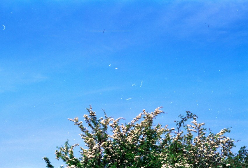 a man flying a kite in a blue sky