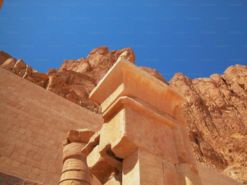 a large stone structure in front of a mountain