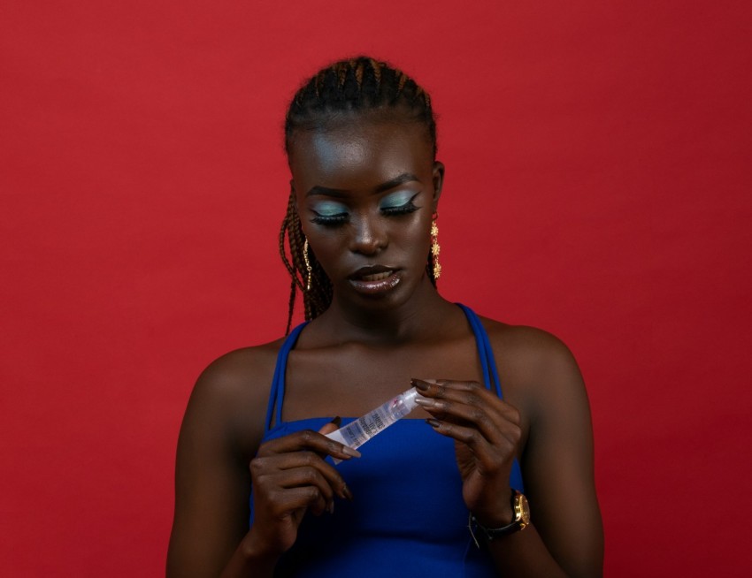 a woman in a blue dress looking at her cell phone