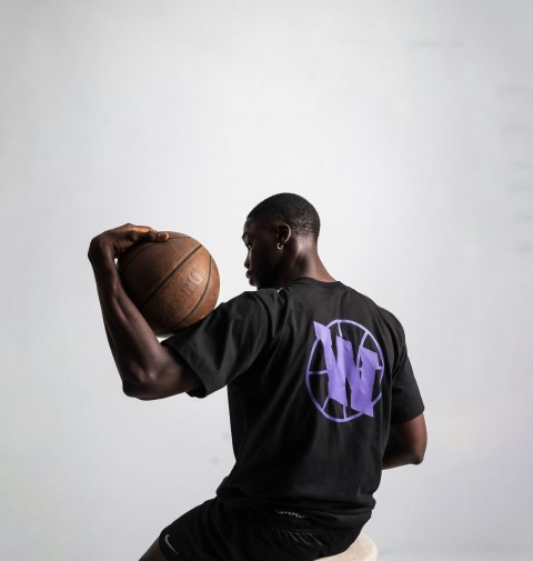 a man sitting on a stool holding a basketball