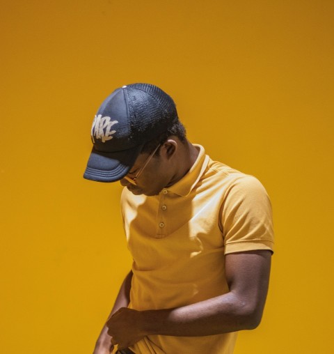 man in yellow sport shirt and black baseball cap e8SfJb