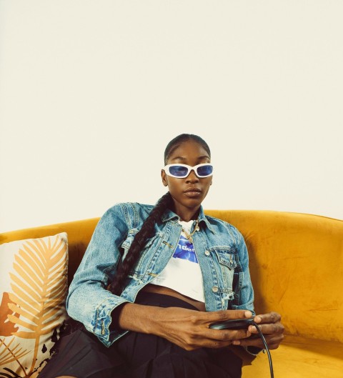 a woman sitting on a couch with a cell phone