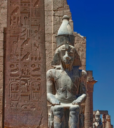 a statue of an egyptian god in front of an egyptian temple