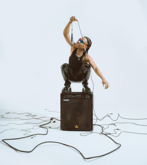 a woman in a black top is sitting on top of a amp vPd2 l