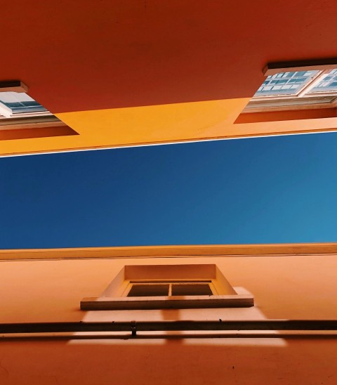 low angle photography of brown concrete buildings under blue sky at daytime