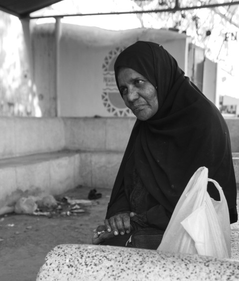 a woman sitting on a bench holding a bag