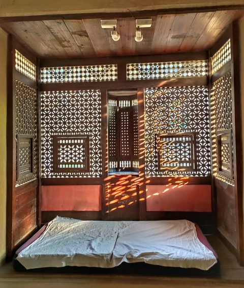 a bed in a room with a wooden wall