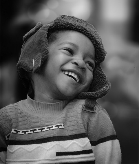 a young boy wearing a hat and smiling