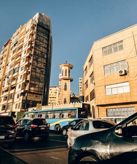 a city street filled with lots of traffic next to tall buildings