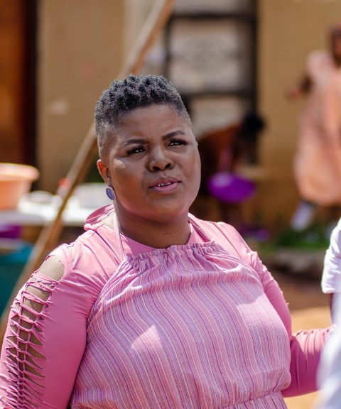 a woman in a pink dress holding a cell phone