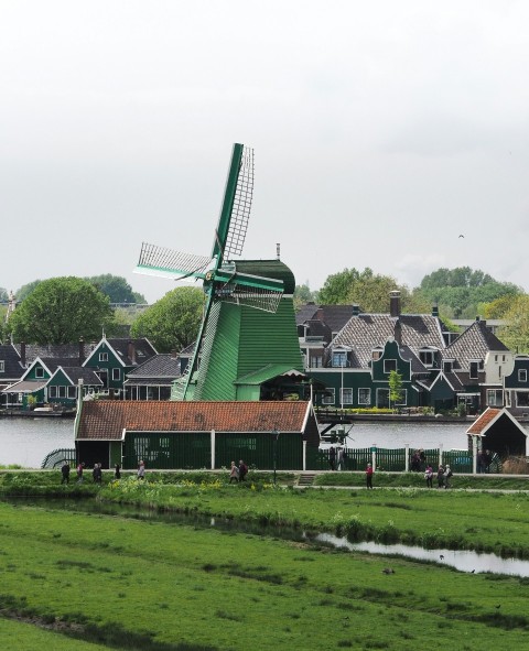 a windmill in the middle of a green field