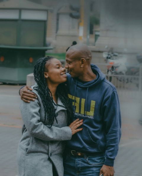 a man and woman standing next to each other and looking at each other