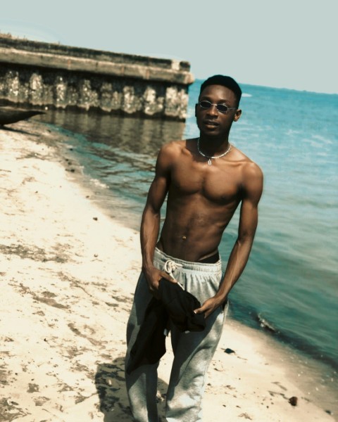 a man standing on a beach next to the ocean