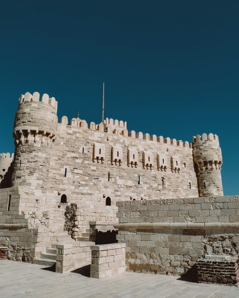 a stone castle with a flag on top of it