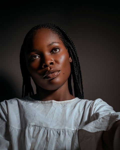 a woman with braids and a white shirt