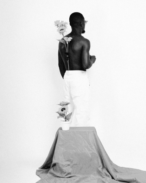 a man standing on top of a table holding a flower