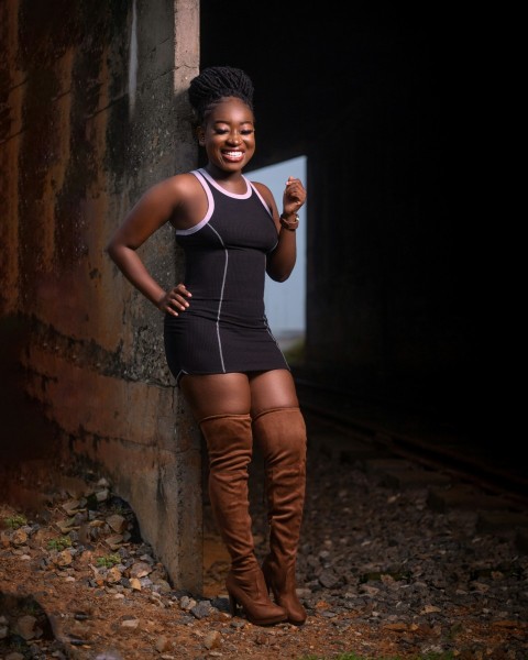 a woman standing next to a brick wall