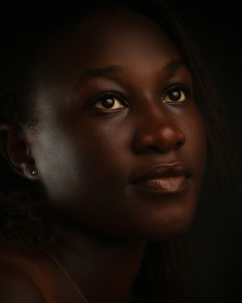 a close up of a womans face with a dark background